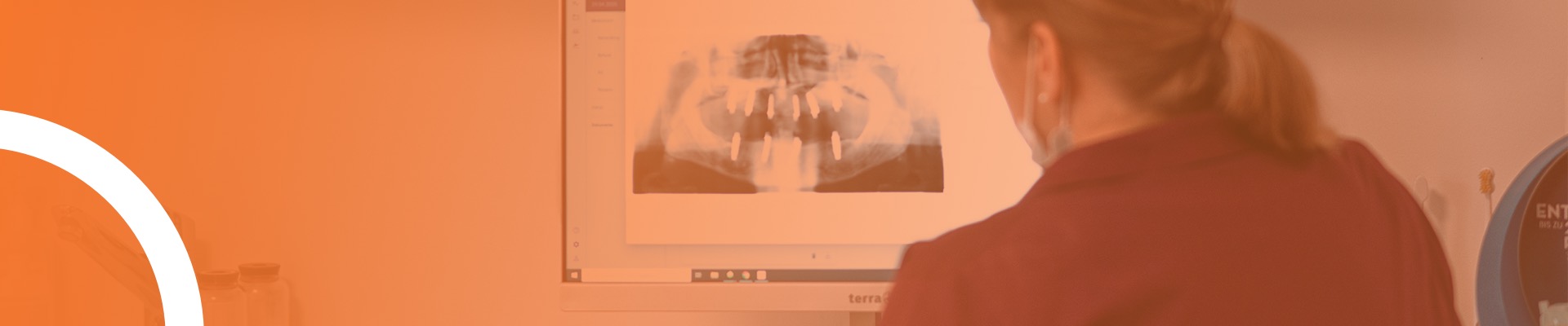 Zahnärztin Angela Jehle schaut sich ein Röntgenbild eines Patienten mit Implantaten an